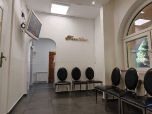 Wnętrze gabinetu stomatologicznego z fotelem dentystycznym i sprzętem medycznym.
